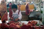 A woman butchering cow parts at San Camilo