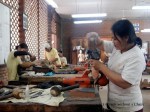 A woman carving a piece at the Artisans Angkor workshop