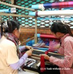 Women demonstrating how a weaving frame is set up at the silk farm
