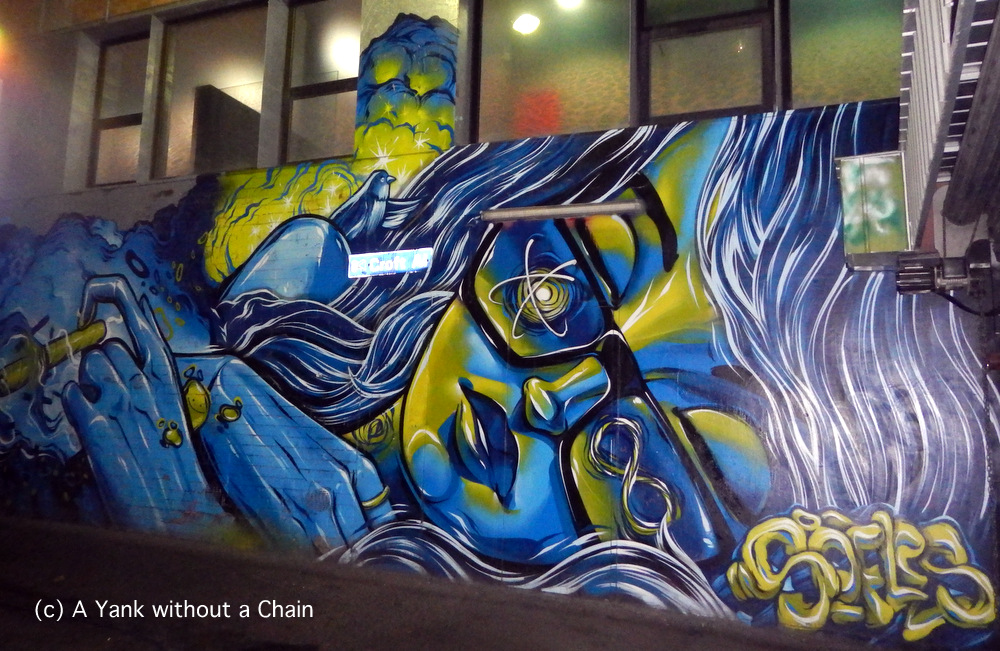 A electric blue mural of a girl on Croft Alley in Chinatown of Melbourne's CBD